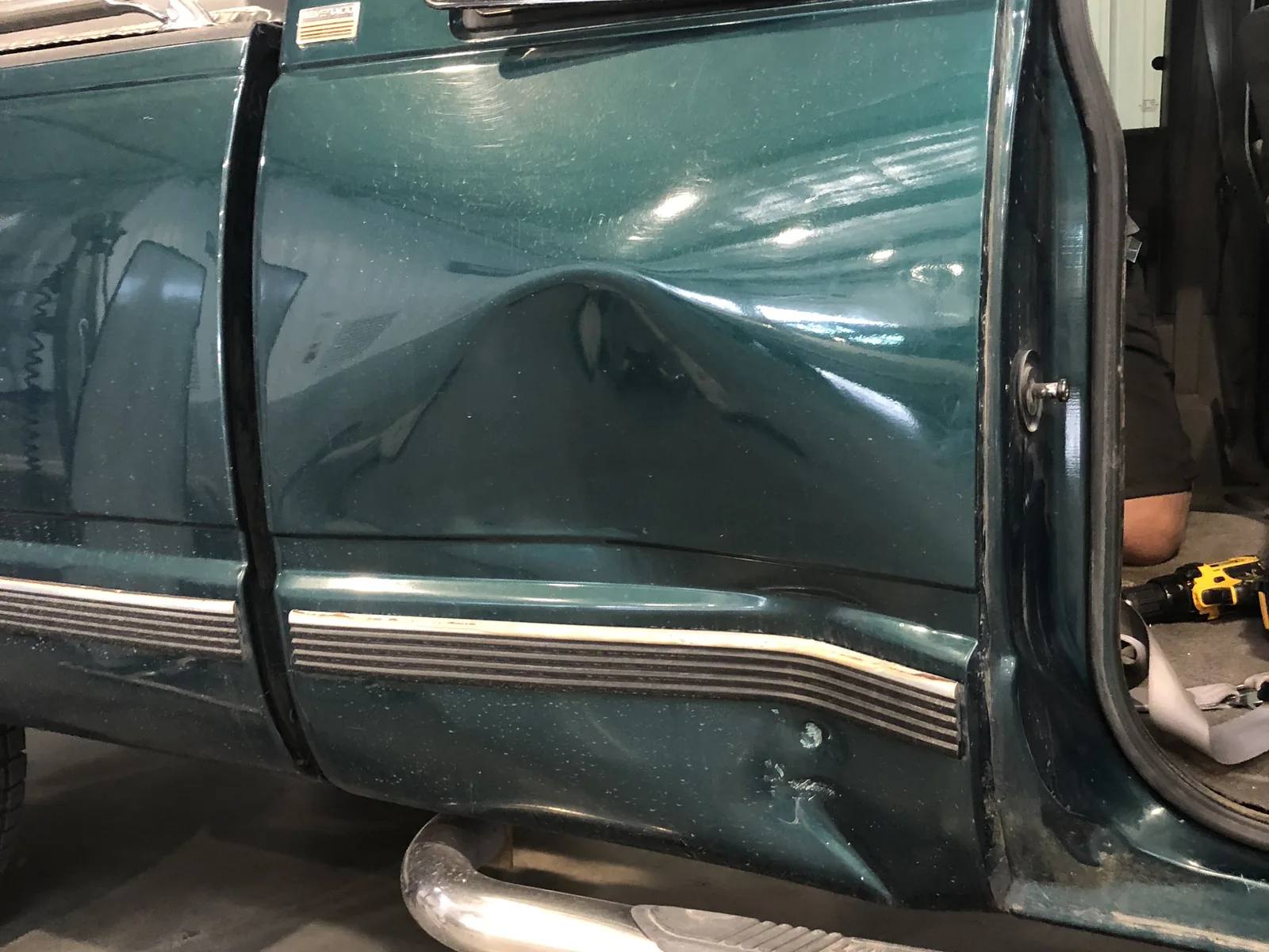 Green truck door dent before paintless dent repair