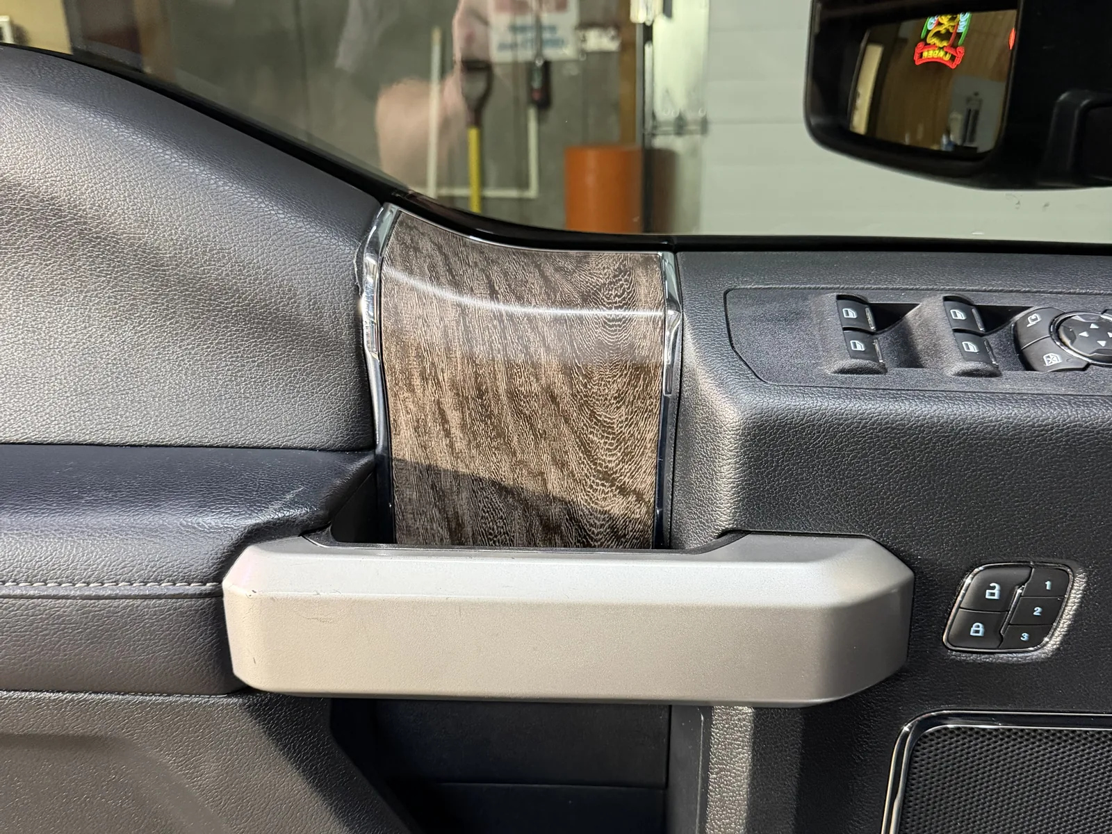 Truck interior door with factory wood-grain trim, before custom overlay